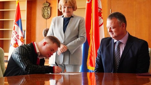 VUK DOBIO UGOVOR O RADU: Mladić sa Daunovim sindromom prva osoba primljena u stalni radni odnos u zdravstvenom sistemu Srbije VUK DOBIO UGOVOR O RADU: Mladić sa Daunovim sindromom prva osoba primljena u stalni radni odnos u zdravstvenom sistemu Srbije