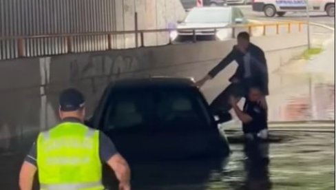 ДРАМАТИЧАН СНИМАК ИЗ БЕОГРАДА: Полицајци спашавају заглављеног човека у возилу испод моста (ВИДЕО)