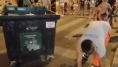 BAGRA BLOKADERA GLEDA  I SMEJE MU SE: Radnik čistoće skuplja prosuto smeće iz kontejnera (VIDEO)
