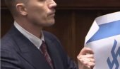 Skandal u poljskom parlamentu: Poslanik za govornicom razvio zastavu Izraela sa kukakstim krstom i to na Dan sećanja na Holokaust (VIDEO)